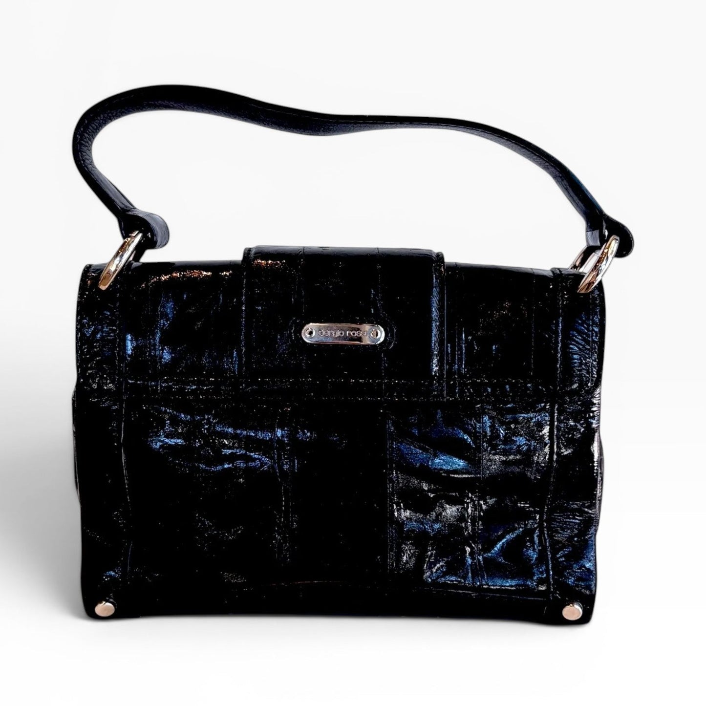 The Pearl black patent leather handbag with a structured rectangular shape, top handle, and silver hardware accents.